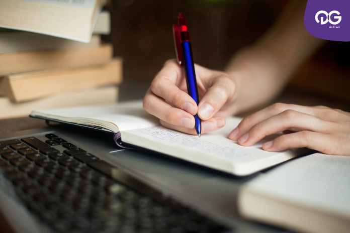 Como se concentrar nos estudos: imagem focando na mão de uma pessoa escrevendo em um caderno